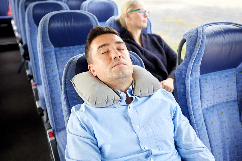 pria tidur dengan nyaman di bus perjalanan