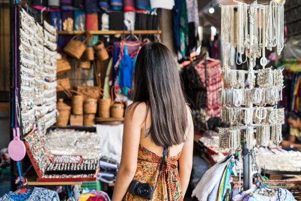 Pelancong wanita muda mencari suvenir di pasar ubud di bali